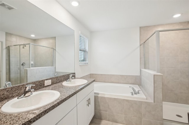 full bathroom featuring double vanity, a stall shower, a sink, and a bath