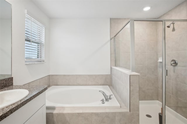 bathroom with recessed lighting, a garden tub, a shower stall, and vanity