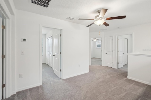 carpeted empty room featuring baseboards and visible vents