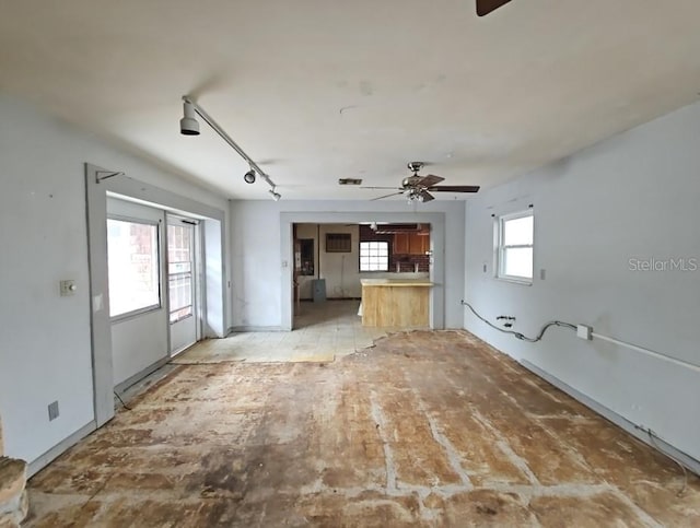 unfurnished living room featuring ceiling fan and rail lighting