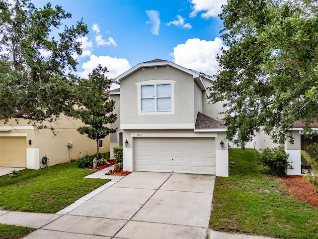 view of front property featuring a garage and a front lawn