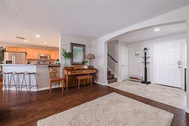 entryway featuring dark wood-type flooring and a textured ceiling