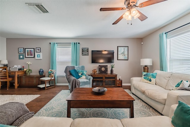 living room featuring dark hardwood / wood-style flooring, a wealth of natural light, and ceiling fan