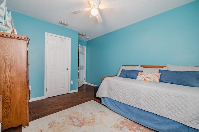 bedroom featuring a textured ceiling, dark wood-type flooring, and ceiling fan