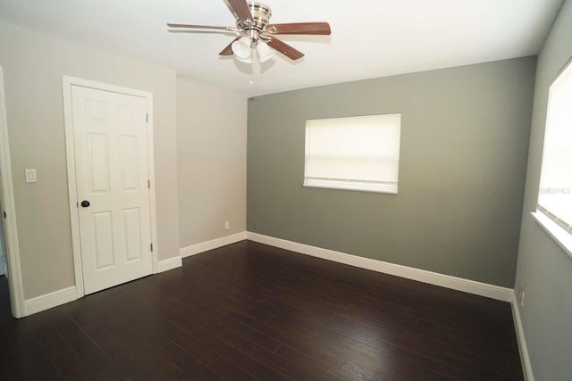 spare room featuring dark wood-type flooring and ceiling fan