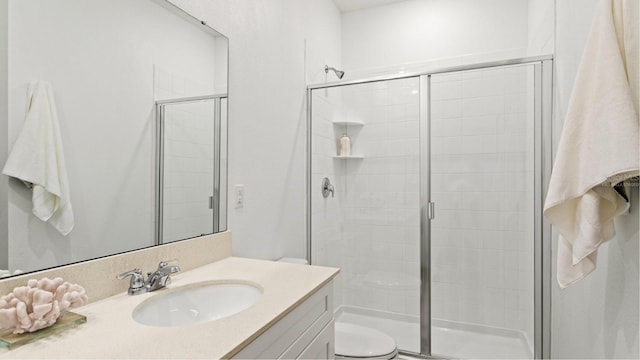 bathroom featuring vanity, an enclosed shower, and toilet