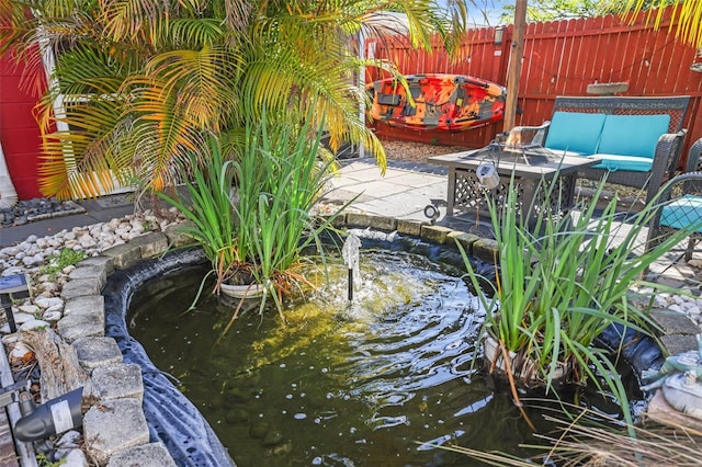 exterior space with a small pond and outdoor lounge area