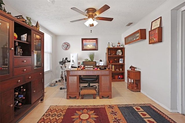 office featuring ceiling fan, light tile patterned floors, and a textured ceiling