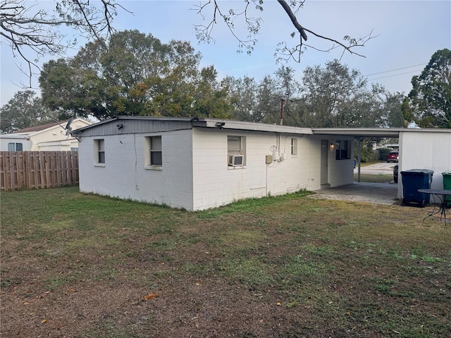 rear view of property with a carport and a yard