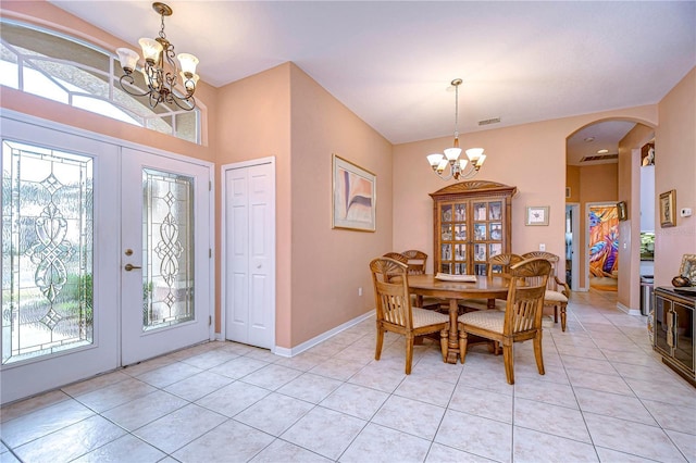 dining area featuring light tile patterned flooring, a wealth of natural light, a chandelier, and french doors