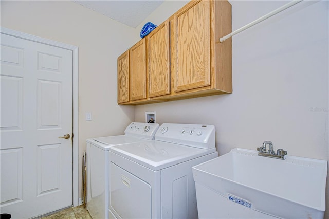 washroom with sink, cabinets, and washing machine and clothes dryer