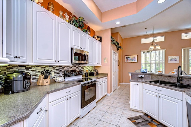 kitchen featuring hanging light fixtures, white cabinetry, sink, and electric range