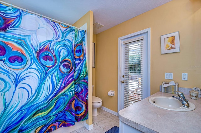 bathroom featuring tile patterned flooring, vanity, a textured ceiling, and toilet