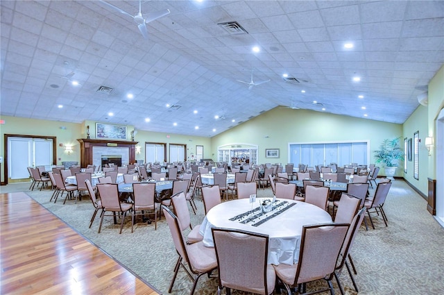 dining space featuring high vaulted ceiling and light hardwood / wood-style floors