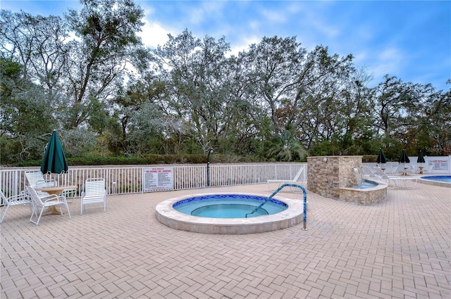 view of pool featuring a community hot tub and a patio