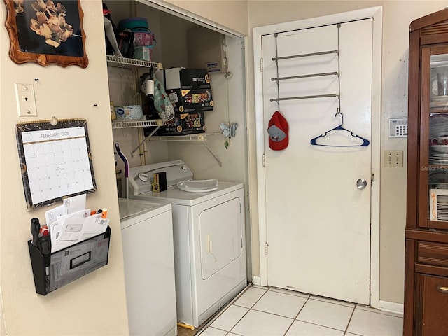 washroom with light tile patterned floors and washer and dryer