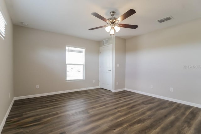 empty room featuring dark wood-type flooring and ceiling fan