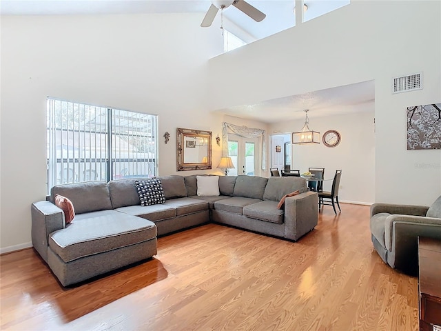 living room with french doors, high vaulted ceiling, ceiling fan, and light hardwood / wood-style flooring