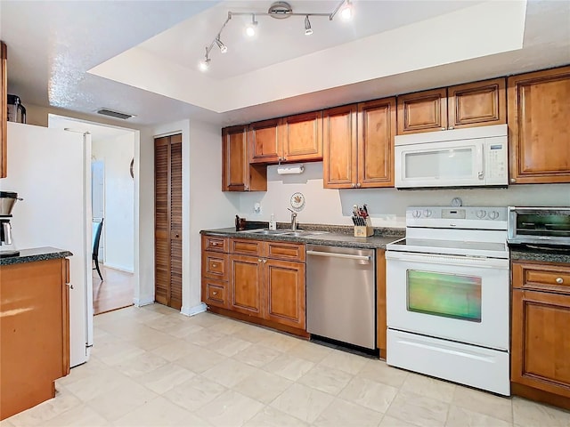 kitchen featuring sink, white appliances, and a raised ceiling