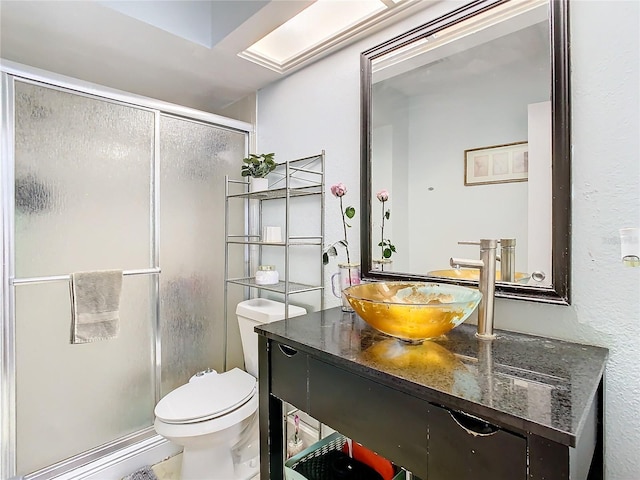 bathroom featuring vanity, toilet, and a shower with door