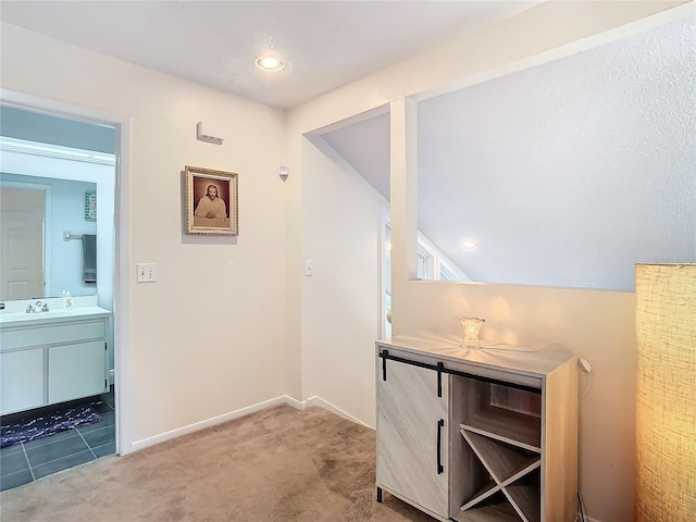 hall with vaulted ceiling, carpet flooring, and sink