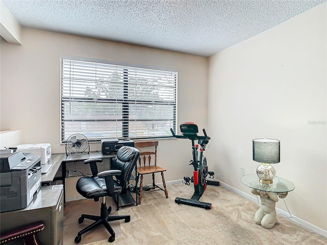 carpeted office featuring a textured ceiling