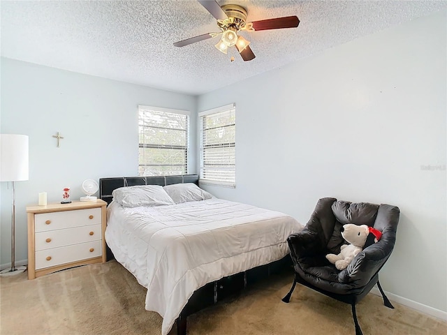 carpeted bedroom with ceiling fan and a textured ceiling