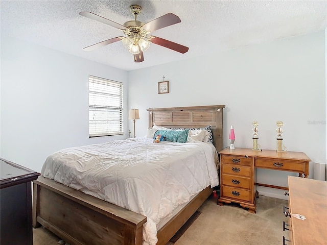 bedroom featuring ceiling fan, light carpet, and a textured ceiling