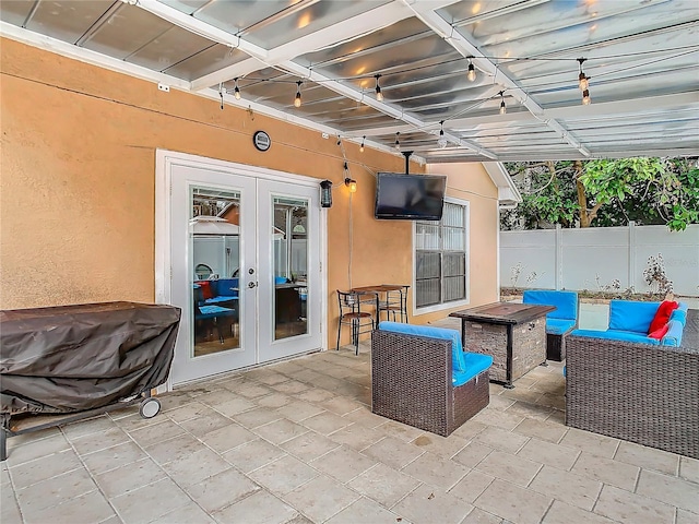 view of patio with french doors and an outdoor living space with a fire pit