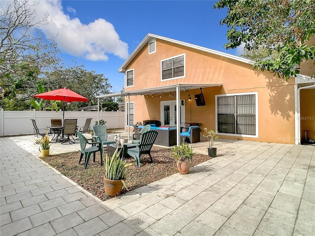 back of house featuring an outdoor living space and a patio