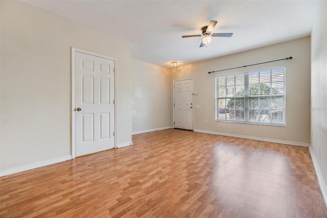 spare room featuring ceiling fan, a textured ceiling, and light hardwood / wood-style flooring