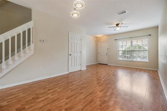 unfurnished living room with hardwood / wood-style floors, a textured ceiling, and ceiling fan