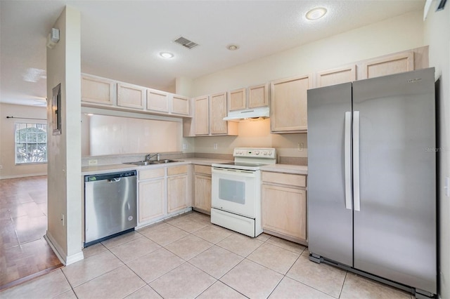 kitchen featuring appliances with stainless steel finishes, sink, light tile patterned floors, and light brown cabinetry