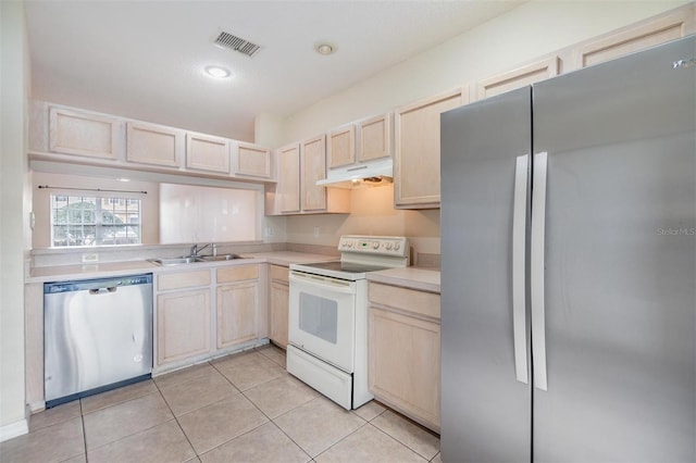 kitchen with appliances with stainless steel finishes, light brown cabinetry, sink, and light tile patterned floors