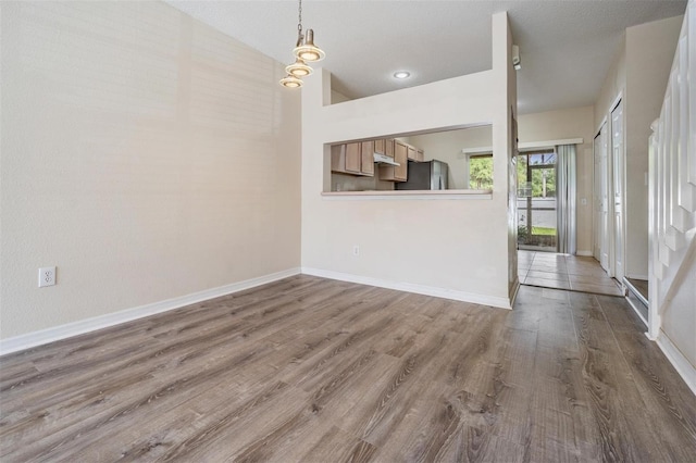 unfurnished living room featuring baseboards and wood finished floors