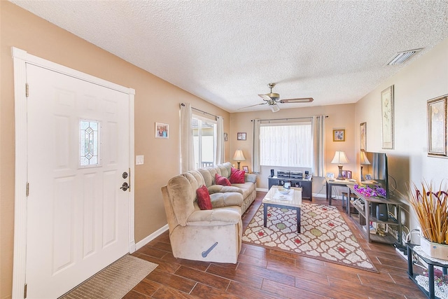 living room with ceiling fan and a textured ceiling