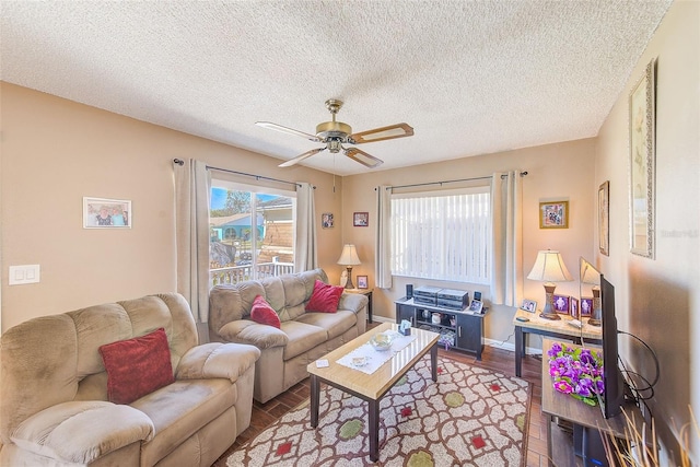 living room featuring a textured ceiling, wood-type flooring, and ceiling fan