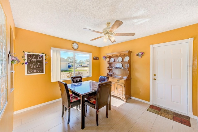 dining area with ceiling fan and a textured ceiling