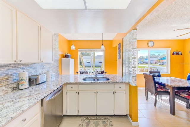 kitchen with pendant lighting, sink, backsplash, stainless steel dishwasher, and kitchen peninsula