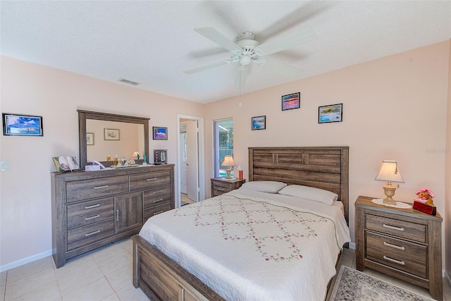 tiled bedroom with ceiling fan and a textured ceiling