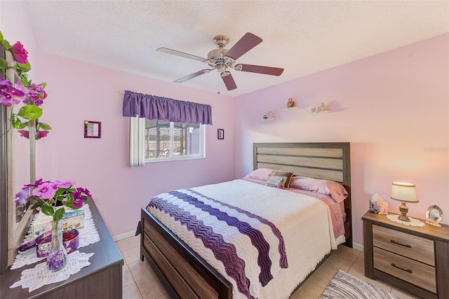 bedroom with ceiling fan, a textured ceiling, and light tile patterned floors