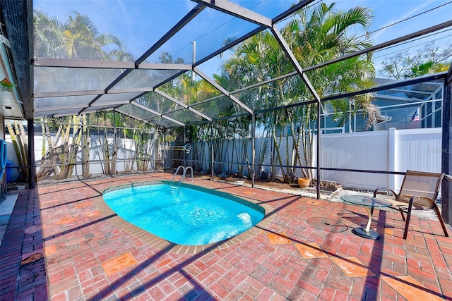 view of swimming pool featuring a patio and a lanai