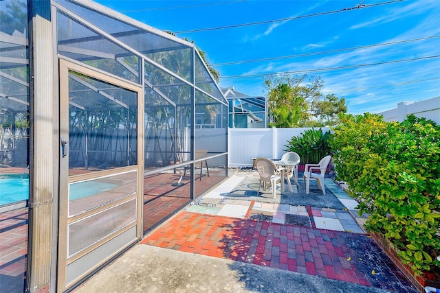 view of patio featuring a lanai