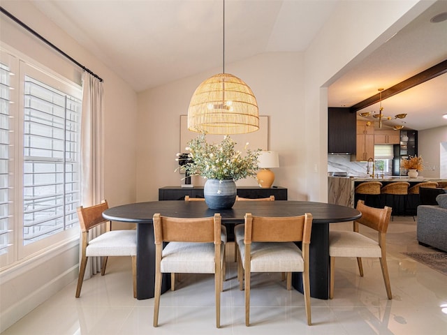 dining area with lofted ceiling with beams, a chandelier, and a healthy amount of sunlight