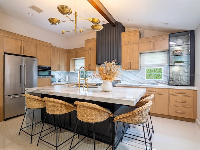 kitchen featuring stainless steel appliances, an island with sink, vaulted ceiling with beams, and a kitchen breakfast bar