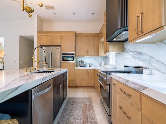 kitchen featuring sink, high end appliances, light stone counters, light tile patterned floors, and backsplash