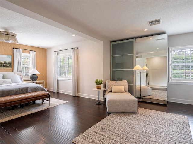 bedroom with dark wood-type flooring and a textured ceiling