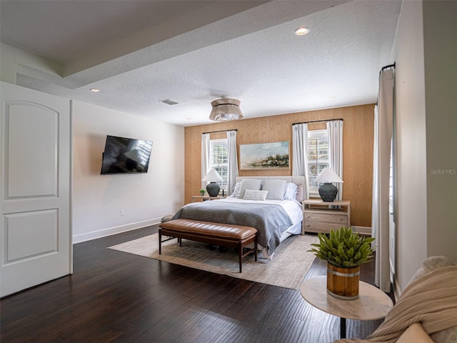 bedroom featuring dark hardwood / wood-style flooring and a textured ceiling