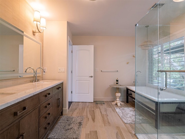 bathroom featuring vanity, separate shower and tub, and wood-type flooring