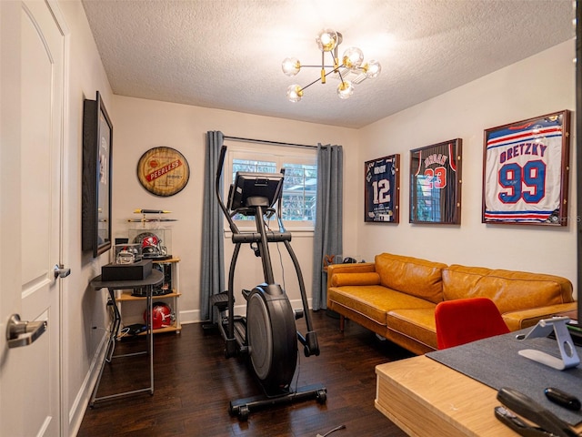 workout area with dark wood-type flooring, a textured ceiling, and a chandelier